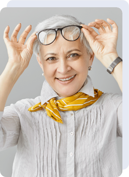 A mature woman happily taking off her glasses and treated cataract